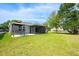 Expansive backyard with a screened lanai, perfect for outdoor entertaining and relaxation in a private setting at 1329 Paradise Dr, Lady Lake, FL 32159