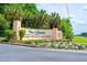 The Villages of Orange Blossom Gardens community sign with lush landscaping and colorful flowers at 1329 Paradise Dr, Lady Lake, FL 32159