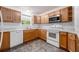 Functional kitchen with white appliances, wooden cabinets, and ample counter space for preparing meals at 1329 Paradise Dr, Lady Lake, FL 32159
