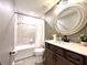 Well-lit bathroom showcasing a bathtub with a shower, modern vanity, stylish mirror, and neutral color palette at 14533 Orchid Island Dr, Orlando, FL 32827