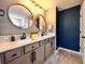 Bright bathroom featuring a double vanity, round mirrors, white countertops, and stylish modern fixtures at 14533 Orchid Island Dr, Orlando, FL 32827