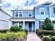 Charming two-story blue home with lush landscaping and a welcoming brick pathway to the front door at 14533 Orchid Island Dr, Orlando, FL 32827