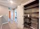 Hallway with multiple doors and an open closet with shelves and drawers for ample storage space at 14533 Orchid Island Dr, Orlando, FL 32827