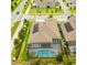 Bird's eye view of home featuring solar panels, paved driveway, manicured lawn and screened-in pool at 14711 Winter Stay Dr, Winter Garden, FL 34787