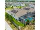 Aerial view of a home with solar panels, manicured lawn, a screened-in pool and paved driveway at 14711 Winter Stay Dr, Winter Garden, FL 34787