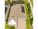 Aerial view of a home with solar panels, a paved driveway, manicured lawn, and white roof at 14711 Winter Stay Dr, Winter Garden, FL 34787