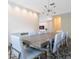Modern dining room featuring a large table with white chairs and a view into the living room at 14711 Winter Stay Dr, Winter Garden, FL 34787