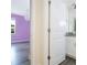 A view into a bedroom with a lilac colored wall and an attached bathroom at 14711 Winter Stay Dr, Winter Garden, FL 34787