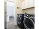 Modern laundry room with black washer and dryer and white cabinets for ample storage at 14711 Winter Stay Dr, Winter Garden, FL 34787