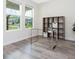 Bright office space featuring a glass desk, wood-look floors, and built-in shelving at 14711 Winter Stay Dr, Winter Garden, FL 34787