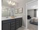 Elegant bathroom with double sinks, gray cabinets, neutral paint and decor, and glass shower at 16147 Coastal Cove Ln, Clermont, FL 34714