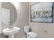 Stylish powder room with round mirror and modern art provides a touch of elegance at 16147 Coastal Cove Ln, Clermont, FL 34714