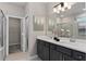 Elegant bathroom with dual sinks, modern vanity, and glass-enclosed shower is the perfect retreat at 16147 Coastal Cove Ln, Clermont, FL 34714