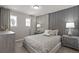 Neutral bedroom with decorative accent wall, side tables, lamps, and natural light from windows at 16147 Coastal Cove Ln, Clermont, FL 34714
