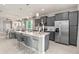 Modern kitchen with a center island, stainless steel appliances, and gray cabinetry at 16147 Coastal Cove Ln, Clermont, FL 34714