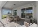 Covered patio with comfortable seating and dining area, leading to a screened backyard at 16147 Coastal Cove Ln, Clermont, FL 34714