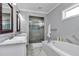 Bathroom featuring a dual sink vanity, soaking tub and a glass-enclosed shower with tile accents at 1819 Sw 29Th St, Ocala, FL 34471