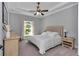 Comfortable bedroom featuring tray ceiling, ceiling fan, and view to the outside through an arched window at 1819 Sw 29Th St, Ocala, FL 34471
