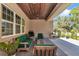 Relaxing covered patio featuring wood ceiling, comfortable green seating, fire pit, and backyard access at 1819 Sw 29Th St, Ocala, FL 34471
