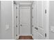 Hallway featuring multiple white paneled doors, trim and wood flooring at 1819 Sw 29Th St, Ocala, FL 34471