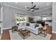 Open-concept living room featuring a comfortable sofa, large windows, and seamless flow to the kitchen at 1819 Sw 29Th St, Ocala, FL 34471