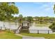 Picturesque view of the boat dock extending into the calm lake waters, surrounded by lush greenery at 201 Cedarwood Dr, Maitland, FL 32751
