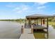 Covered boat dock on a calm lake, offering a peaceful retreat for water activities and relaxation at 201 Cedarwood Dr, Maitland, FL 32751