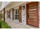 Close-up of the front entrance showcasing a modern wood door, stylish light fixture, and whitewashed brick detail at 201 Cedarwood Dr, Maitland, FL 32751