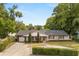 Attractive one-story home with a circular driveway, trimmed hedges and a two-car garage at 201 Cedarwood Dr, Maitland, FL 32751