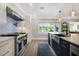 Well-lit kitchen featuring stainless steel appliances, contrasting cabinetry, and a picturesque view from the window at 201 Cedarwood Dr, Maitland, FL 32751