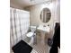 Well-lit bathroom featuring a pedestal sink, black and white floors and a shower with a striped curtain at 2053 #E Dixie Belle Dr # E, Orlando, FL 32812
