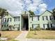 Inviting two-story apartment building with soft green paint, black shutters, and a welcoming entryway at 2053 #E Dixie Belle Dr # E, Orlando, FL 32812