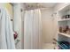 This bathroom features a shower with a shower curtain, a towel rack, and a shelving unit at 2070 Keyes Ln, Deltona, FL 32738