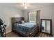 Bedroom with wooden frame bed, hardwood floors, and natural lighting from a window at 2070 Keyes Ln, Deltona, FL 32738