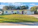 Quaint one-story home with a vibrant red door, tidy lawn, and attached single-car garage at 2070 Keyes Ln, Deltona, FL 32738