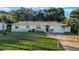 Well-kept one-story home featuring an attached garage, red door, and manicured lawn with landscaping at 2070 Keyes Ln, Deltona, FL 32738