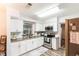 Bright kitchen with granite countertops, white cabinetry, stainless appliances and a view into dining area at 2070 Keyes Ln, Deltona, FL 32738