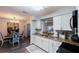 Modern kitchen featuring granite counters, white cabinetry, and an open view into the dining room at 2070 Keyes Ln, Deltona, FL 32738