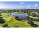 Breathtaking aerial view of a well-maintained golf course community with a beautiful lake and lush greenery at 2081 The Oaks Blvd, Kissimmee, FL 34746