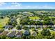 Beautiful aerial view of the neighborhood featuring well-maintained homes, lush trees and pond at 2081 The Oaks Blvd, Kissimmee, FL 34746