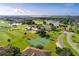Picturesque aerial view of a golf course community with ponds, tennis courts, and lush landscaping at 2081 The Oaks Blvd, Kissimmee, FL 34746