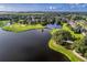 An aerial view of the community showcases a lake, golf course, and residential area at 2081 The Oaks Blvd, Kissimmee, FL 34746
