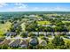 Aerial view of the home near a golf course and ponds in a neighborhood surrounded by trees at 2081 The Oaks Blvd, Kissimmee, FL 34746