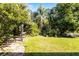Secluded backyard featuring a pergola, mature trees, and well-maintained lawn at 2081 The Oaks Blvd, Kissimmee, FL 34746