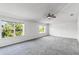 Spacious bedroom with two large windows, a ceiling fan, neutral walls, and carpet flooring at 2081 The Oaks Blvd, Kissimmee, FL 34746