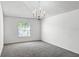 Neutral bedroom with a chandelier, carpet, and a window offers a calming, adaptable space at 2081 The Oaks Blvd, Kissimmee, FL 34746