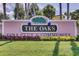 Entrance sign to 'The Oaks Golf Club & Community', with flowers and manicured lawn at 2081 The Oaks Blvd, Kissimmee, FL 34746