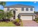 Charming two-story home features a manicured front yard, brick driveway, and an attached two-car garage at 2081 The Oaks Blvd, Kissimmee, FL 34746