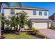 Charming two-story home featuring a well-manicured lawn, brick driveway, and attached two-car garage at 2081 The Oaks Blvd, Kissimmee, FL 34746