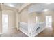 Second floor hallway featuring neutral walls and carpet, white railing, and archways to other rooms at 2081 The Oaks Blvd, Kissimmee, FL 34746